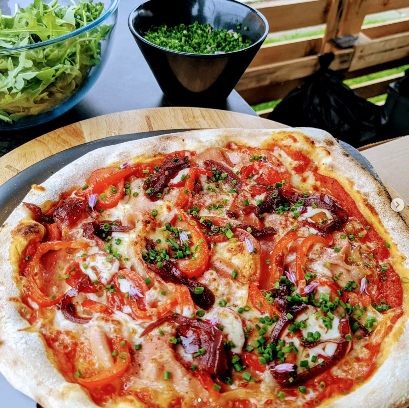 Med veg pizza on a wooden board with salad