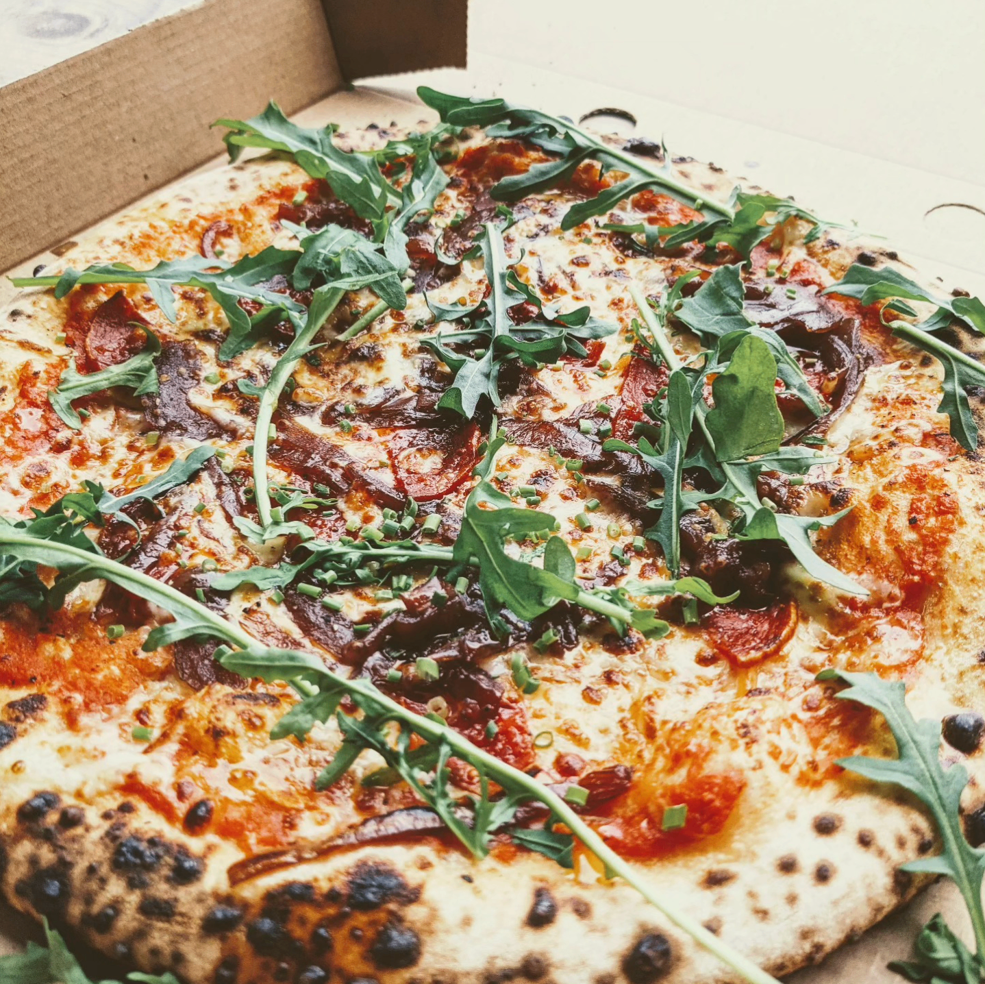 Pepperoni pizza with rocket in a box